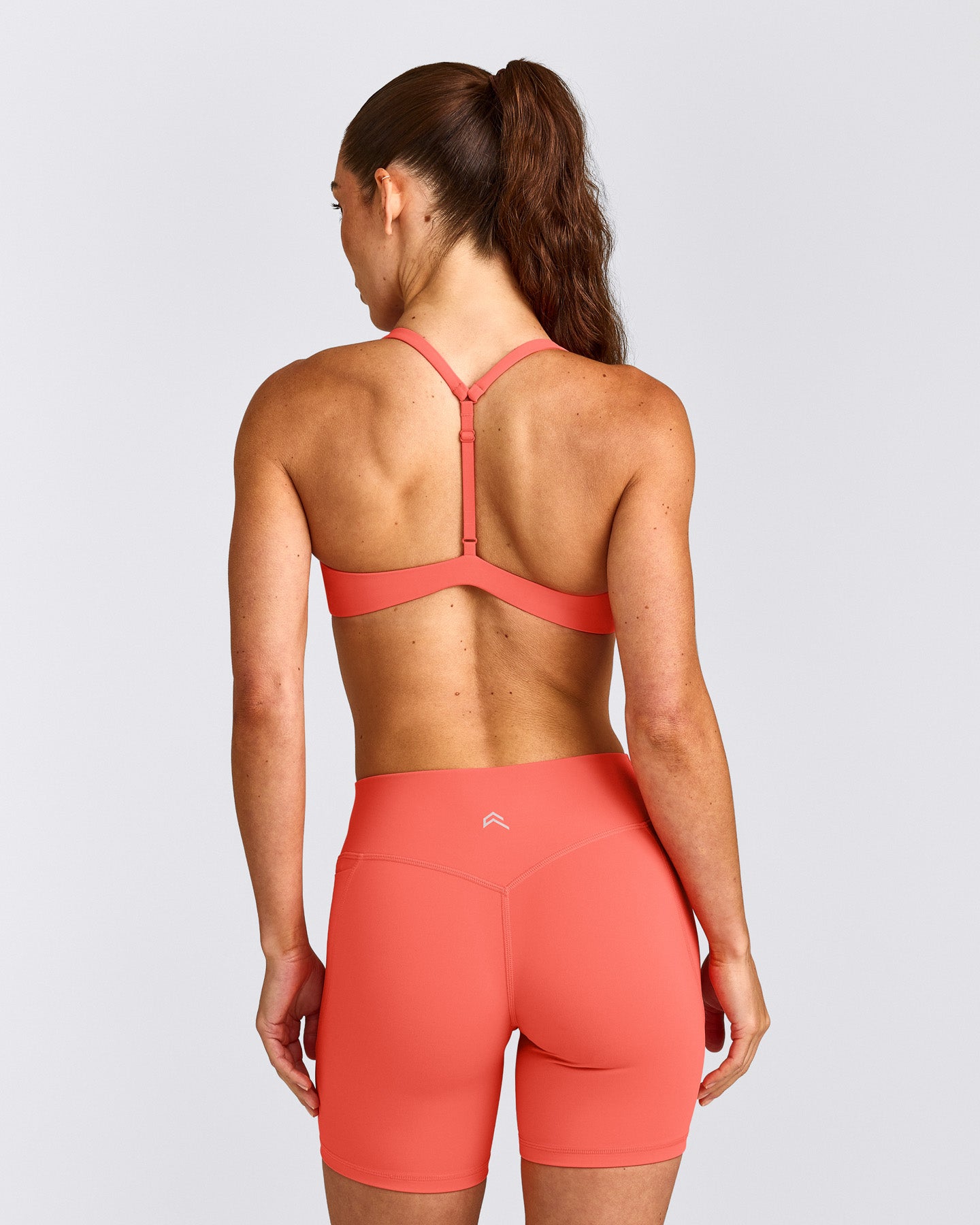 UnifiedMove™ T Back Minimal Bralette with Reflective Logo | Light Charged Coral